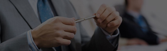 A man in a suit holding a pen